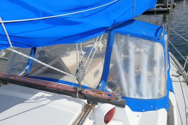 Slide: The Image of 1991 Catalina 36 sailboat with blue canvas cover and clear windows. - 42