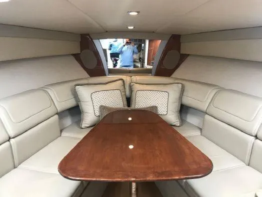 Slide: The Image of 2017 Formula 350 Sun Sport cabin with beige seating and wooden table. - 25