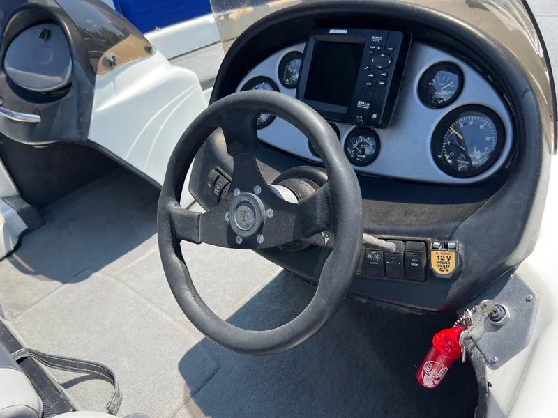 Slide: The Image of 2000 Triton TR170C boat dashboard with steering wheel, gauges, and navigation system. - 15