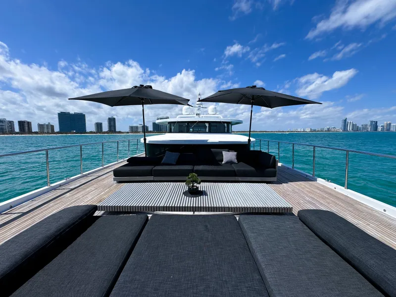Slide: The Image of Luxurious 2010 Custom WHS Marine yacht with sun loungers and umbrellas on deck, city skyline in background. - 28