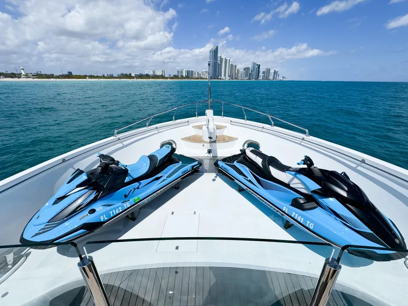 Slide: The Image of Two jet skis on the deck of a 2010 Custom WHS Marine yacht, ocean and cityscape in background. - 42
