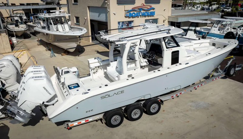 Slide: The Image of 2024 Solace 37 CS boat on a trailer at a dealership, featuring triple Mercury outboard engines. - 1