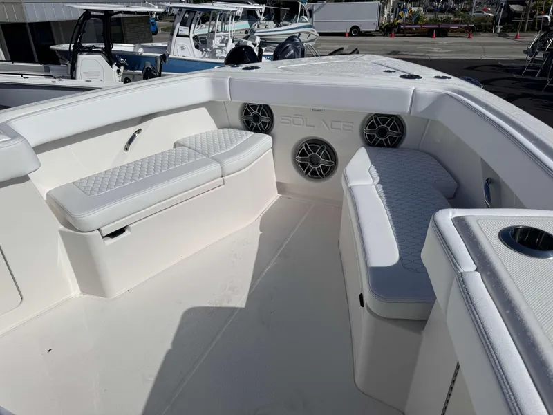 Slide: The Image of Interior seating area of 2024 Solace 37 CS boat with cushioned benches and speakers. - 14