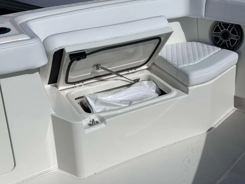 Slide: The Image of Open storage compartment on 2024 Solace 37 CS boat with white cushioned seating. - 16