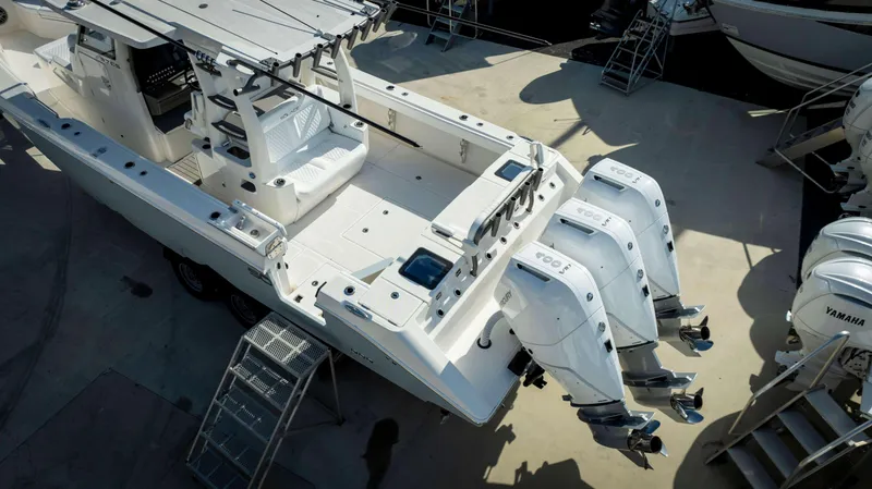 Slide: The Image of 2024 Solace 37 CS boat with triple outboard engines, docked on a trailer. - 24