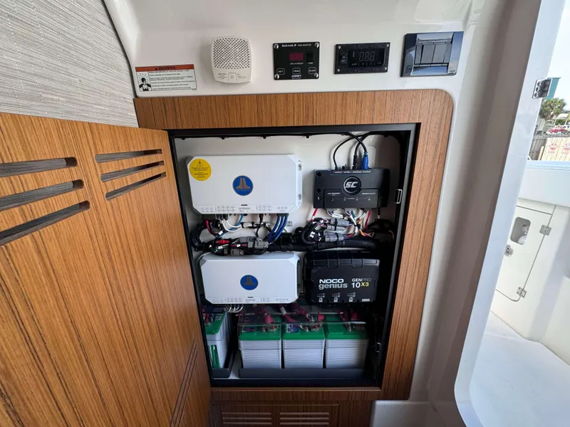 Slide: The Image of Electrical system compartment of 2024 Solace 37 CS boat with NOCO Genius charger. - 26