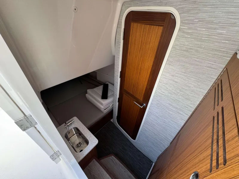 Slide: The Image of 2024 Solace 37 CS cabin interior with wooden door, sink, and bed. - 28