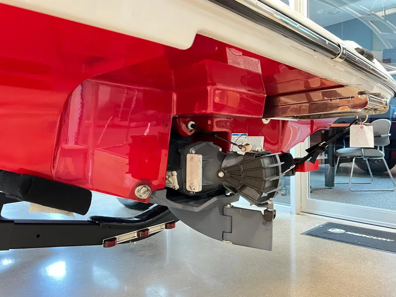 Slide: The Image of 2024 Yamaha AR 195 boat's red hull and jet drive system in showroom. - 2