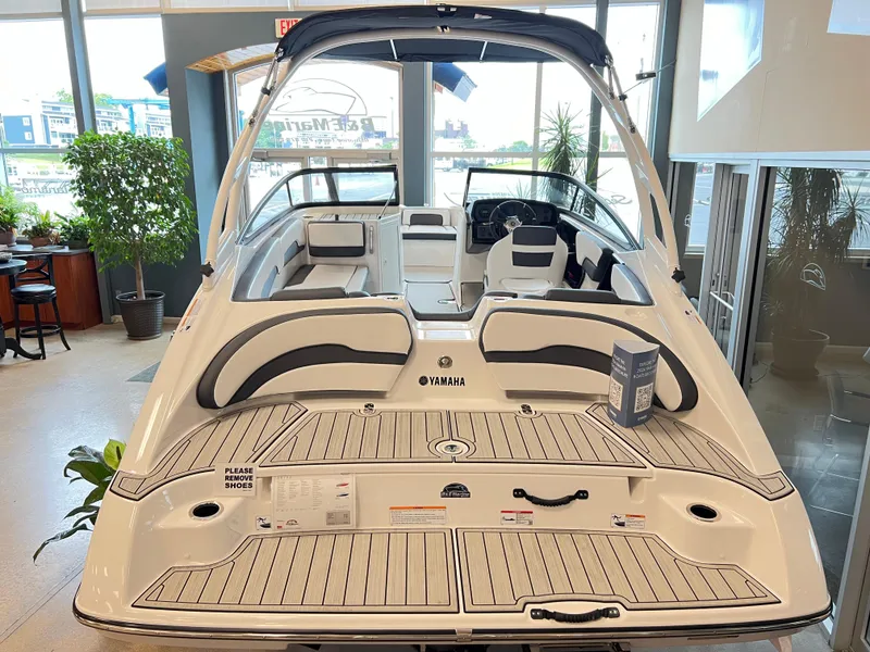 Slide: The Image of 2024 Yamaha Boats AR 195 interior view in showroom, featuring sleek seating and modern design. - 3
