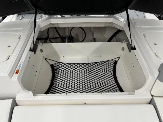 Slide: The Image of 2024 Chaparral 23 SSi OB boat storage compartment with netting. - 17