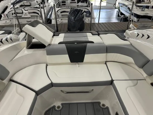 Slide: The Image of 2024 Chaparral 23 SSi OB boat interior with cushioned seating and outboard motor. - 20