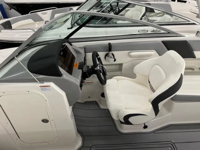 Slide: The Image of 2024 Chaparral 23 SSi OB boat interior with white captain's seat and dashboard. - 7