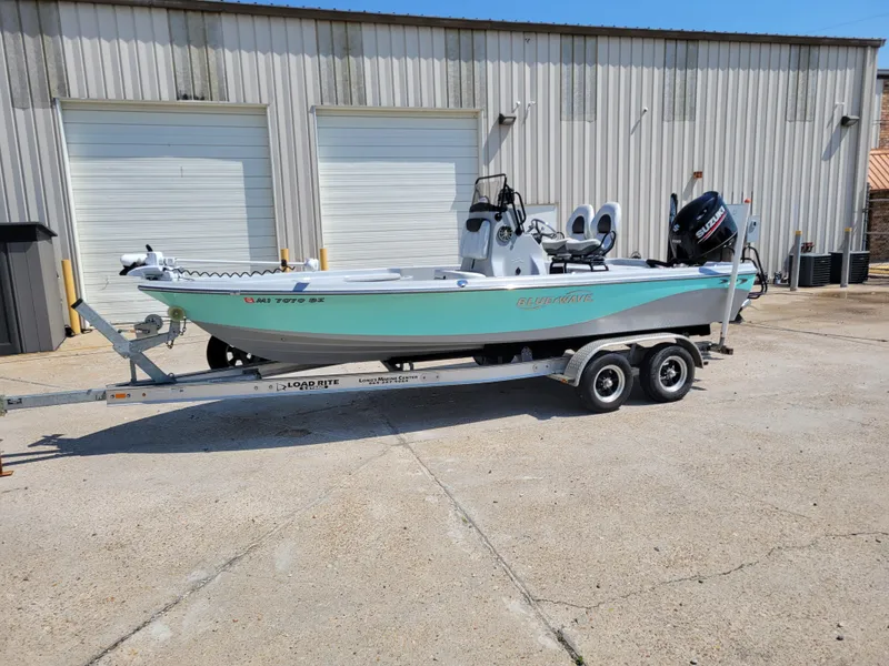 Slide: The Image of 2017 Blue Wave 2200 PureBay boat on a trailer in front of a warehouse. - 2