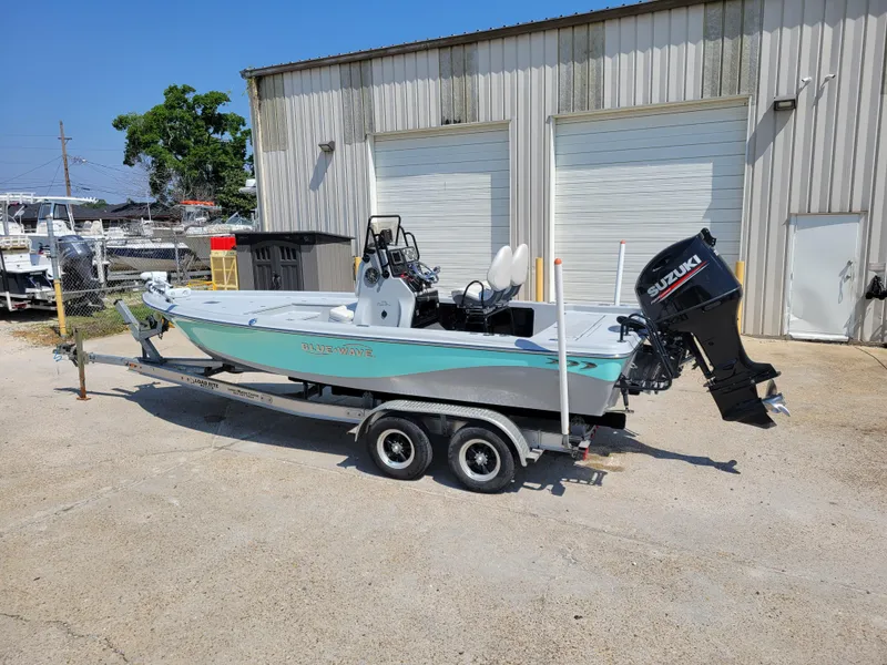 Slide: The Image of 2017 Blue Wave 2200 PureBay boat on a trailer outside a warehouse. - 4