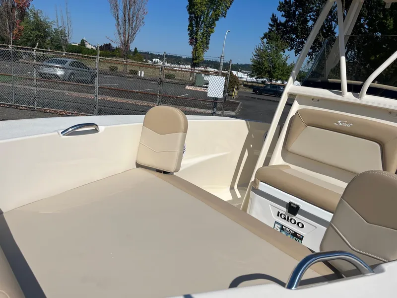 Slide: The Image of 2024 Scout 195 Sportfish boat interior with beige seating and Igloo cooler. - 5
