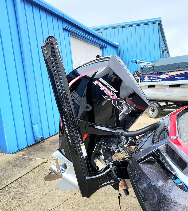 Slide: The Image of 2024 Ranger Z520R boat with Mercury Pro XS engine, parked near blue building. - 2