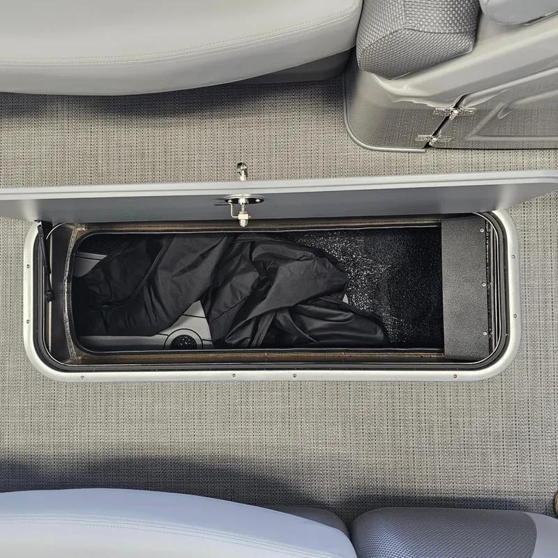 Slide: The Image of 2024 Regency 250 LE3 Sport storage compartment with black cover inside. - 11