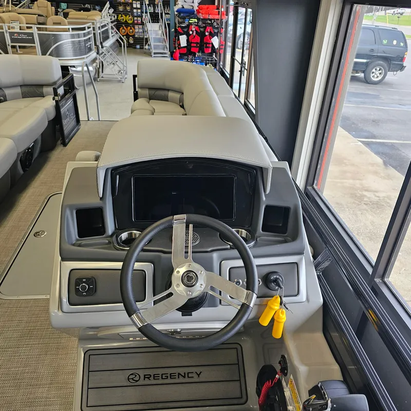 Slide: The Image of 2024 Regency 250 LE3 Sport boat interior with steering wheel and seating. - 14