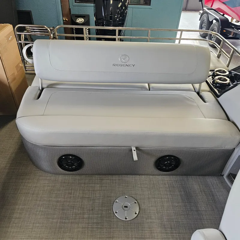 Slide: The Image of 2024 Regency 250 LE3 Sport boat interior with cushioned seating and built-in speakers. - 23