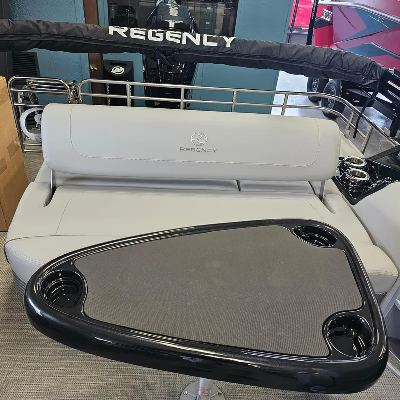Slide: The Image of 2024 Regency 250 LE3 Sport boat interior with cushioned seating and table. - 24