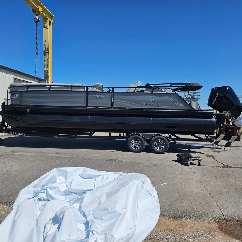 Slide: The Image of 2024 Regency 250 LE3 Sport pontoon boat on trailer at dockyard. - 3