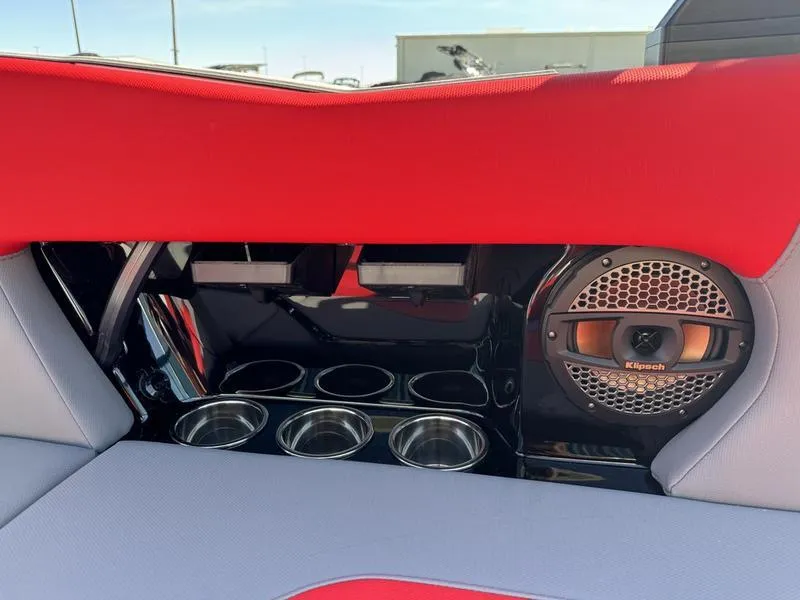 Slide: The Image of 2024 MasterCraft NXT 22 boat interior with red upholstery, cup holders, and Klipsch speaker. - 21