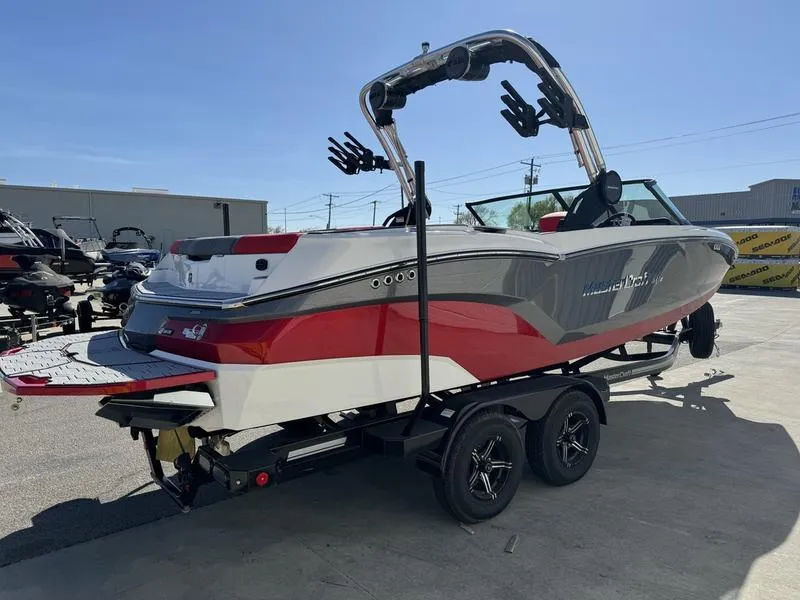 Slide: The Image of 2024 MasterCraft NXT 22 boat on a trailer, rear view, in a marina. - 5