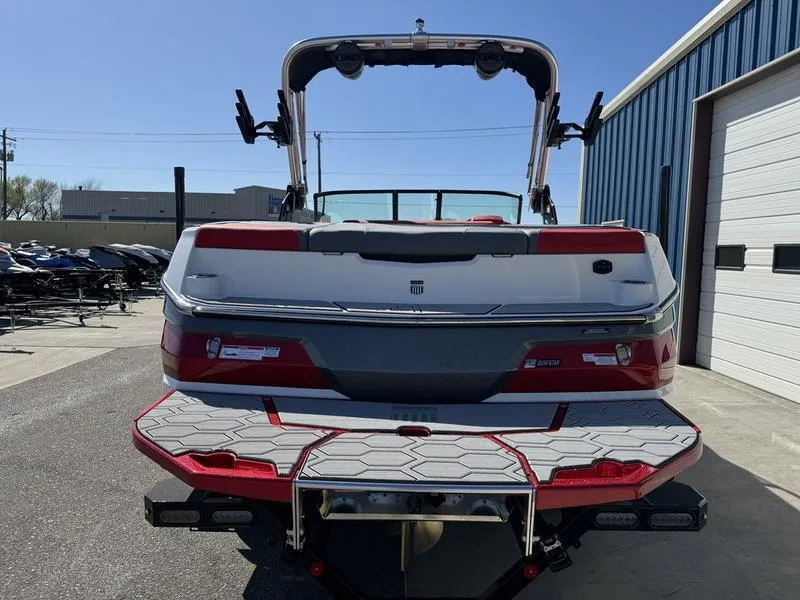 Slide: The Image of 2024 MasterCraft NXT 22 boat rear view at a marina. - 6