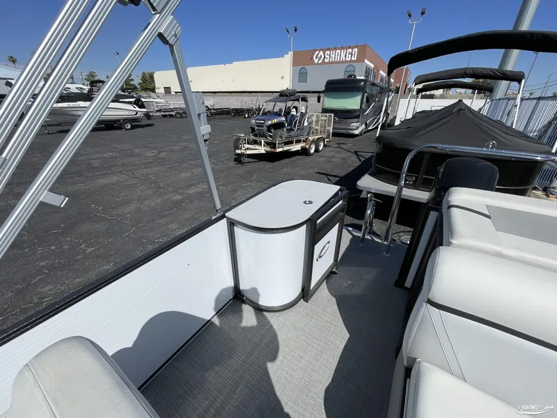 Slide: The Image of 2023 Crest 200 LX L Classic pontoon boat interior at a dealership. - 7