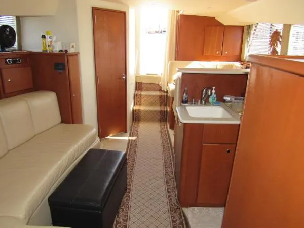 Slide: The Image of Interior of 2004 Silverton 330 Sport Bridge yacht with beige seating and wooden cabinetry. - 10