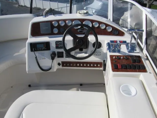 Slide: The Image of 2004 Silverton 330 Sport Bridge helm with steering wheel and control panel. - 19