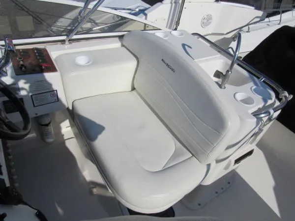 Slide: The Image of 2004 Silverton 330 Sport Bridge helm seat with white upholstery and control panel. - 20