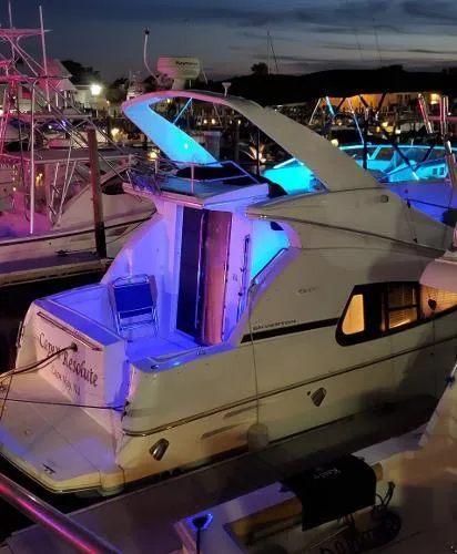 Slide: The Image of 2004 Silverton 330 Sport Bridge yacht docked at night with blue LED lights. - 8