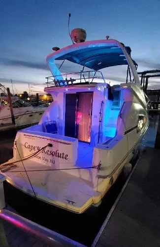Slide: The Image of 2004 Silverton 330 Sport Bridge yacht docked at sunset with colorful lights. - 9