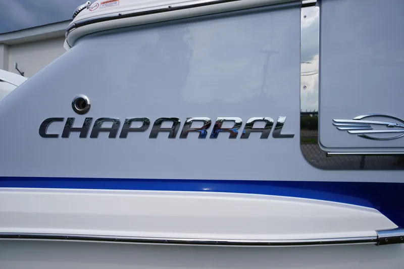 Slide: The Image of 2025 Chaparral 280 OSX boat logo on sleek gray and blue exterior. - 12