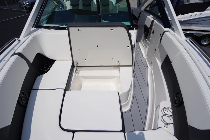 Slide: The Image of 2025 Chaparral 280 OSX boat interior with open storage compartment and seating area. - 18