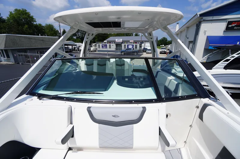 Slide: The Image of 2025 Chaparral 280 OSX boat with sleek design and spacious seating, displayed outdoors. - 21