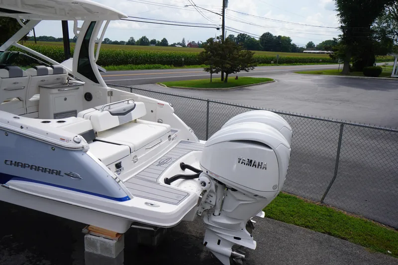 Slide: The Image of 2025 Chaparral 280 OSX boat with Yamaha outboard motor, parked near a road. - 3