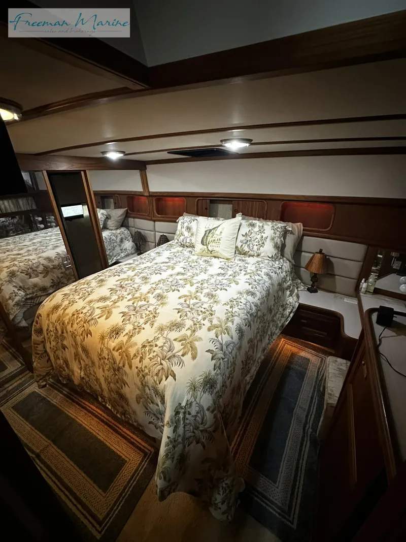 Slide: The Image of 1988 Carver 4207 Aft Cabin bedroom with floral bedding and cozy lighting. - 11