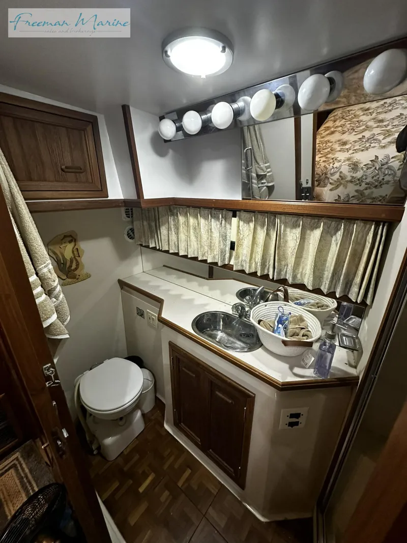 Slide: The Image of 1988 Carver 4207 Aft Cabin bathroom with sink, toilet, and storage cabinets. - 15