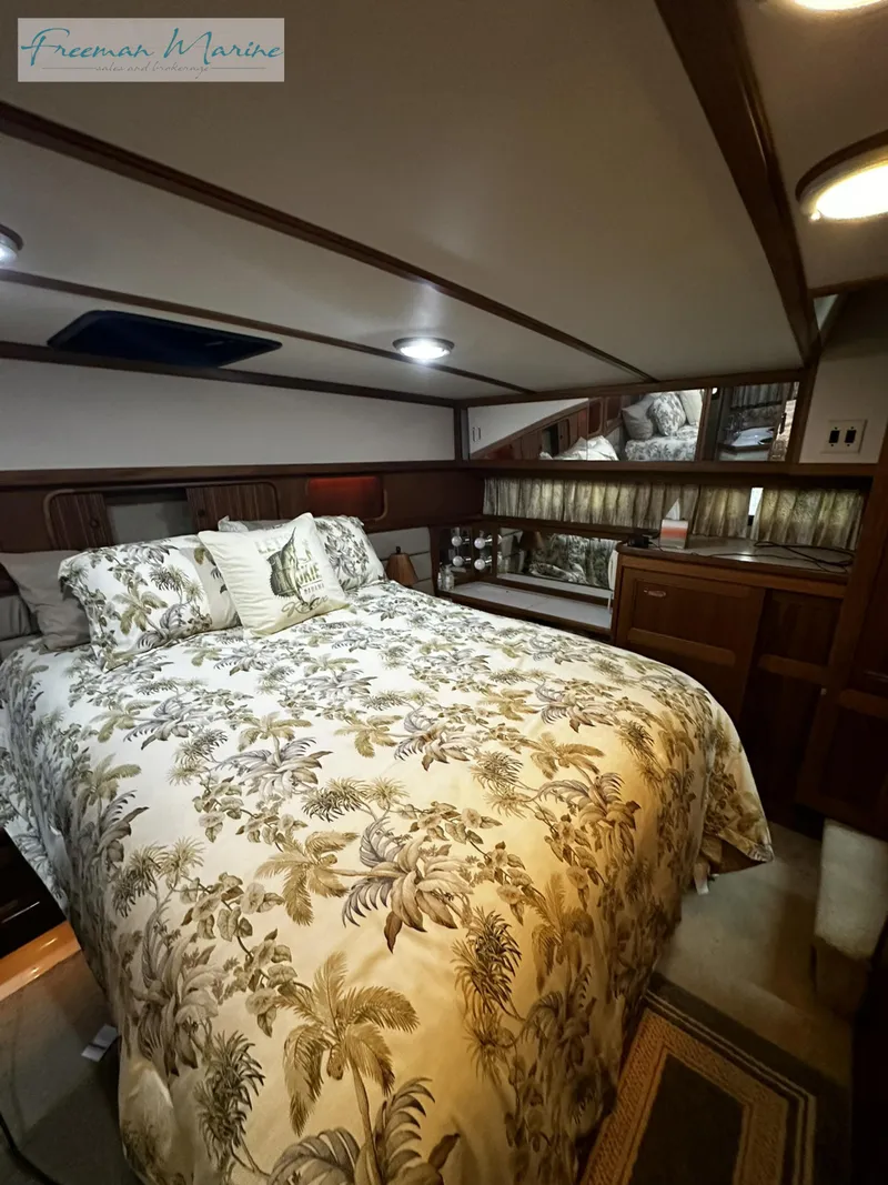 Slide: The Image of 1988 Carver 4207 Aft Cabin bedroom with floral bedding and wood accents. - 16