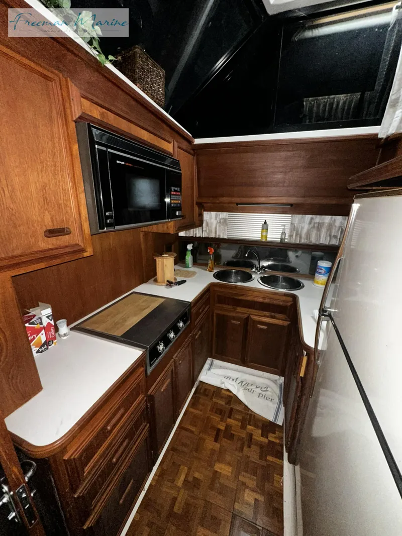 Slide: The Image of 1988 Carver 4207 Aft Cabin kitchen with wood cabinetry and modern appliances. - 25