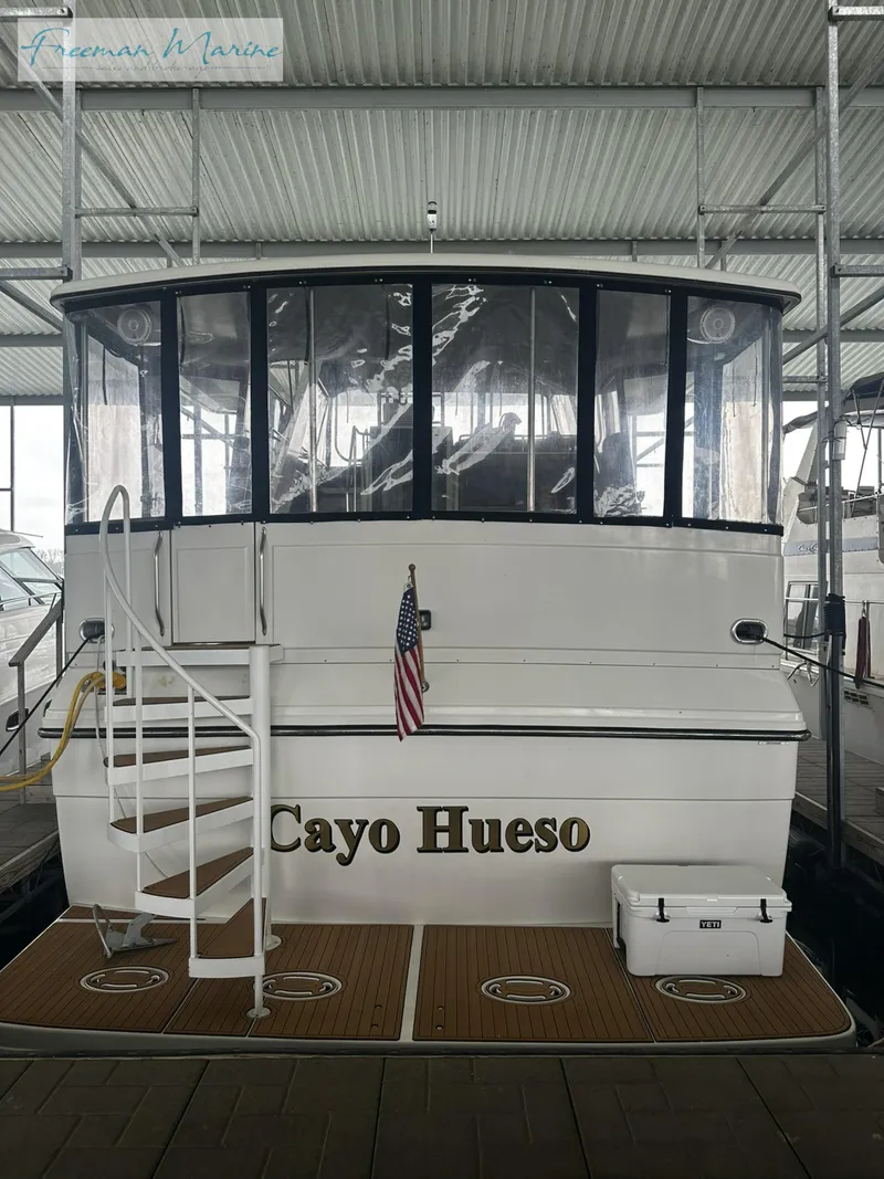 Slide: The Image of 1988 Carver 4207 Aft Cabin yacht docked, featuring "Cayo Hueso" name and American flag. - 3