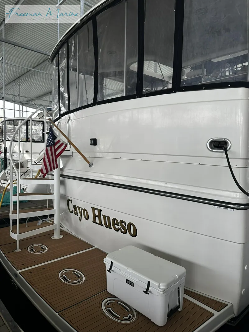 Slide: The Image of 1988 Carver 4207 Aft Cabin yacht with "Cayo Hueso" name and American flag. - 35
