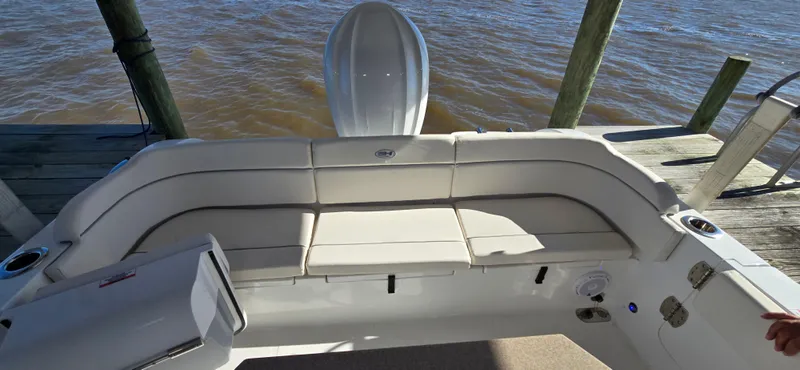 Slide: The Image of 2023 Sea Hunt Escape 250 boat with spacious seating area docked by the water. - 15