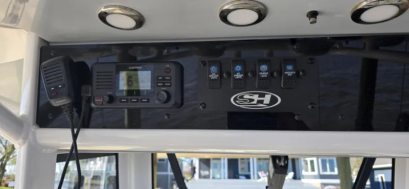 Slide: The Image of Control panel of a 2023 Sea Hunt Escape 250 boat with radio and switches. - 2