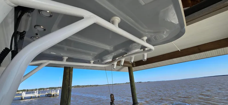 Slide: The Image of 2023 Sea Hunt Escape 250 boat under a dock with a view of the water. - 21