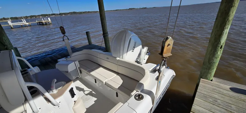 Slide: The Image of 2023 Sea Hunt Escape 250 boat docked by the water. - 27