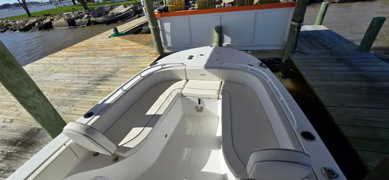 Slide: The Image of 2023 Sea Hunt Escape 250 boat docked, featuring spacious seating and sleek design. - 4