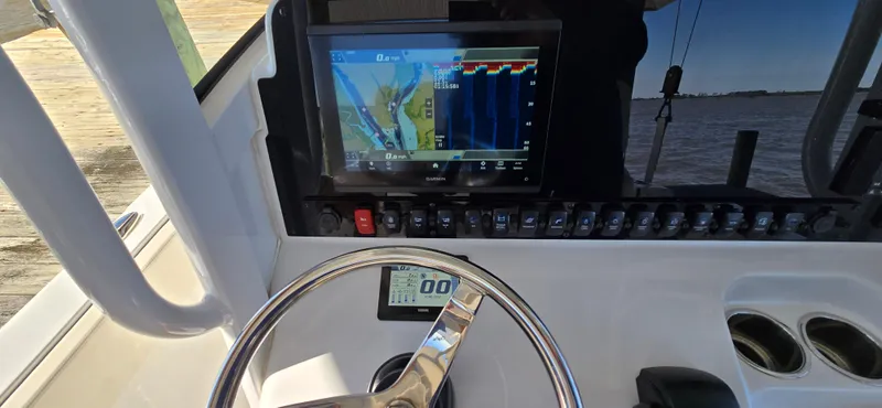 Slide: The Image of 2023 Sea Hunt Escape 250 boat dashboard with navigation screen and steering wheel. - 7